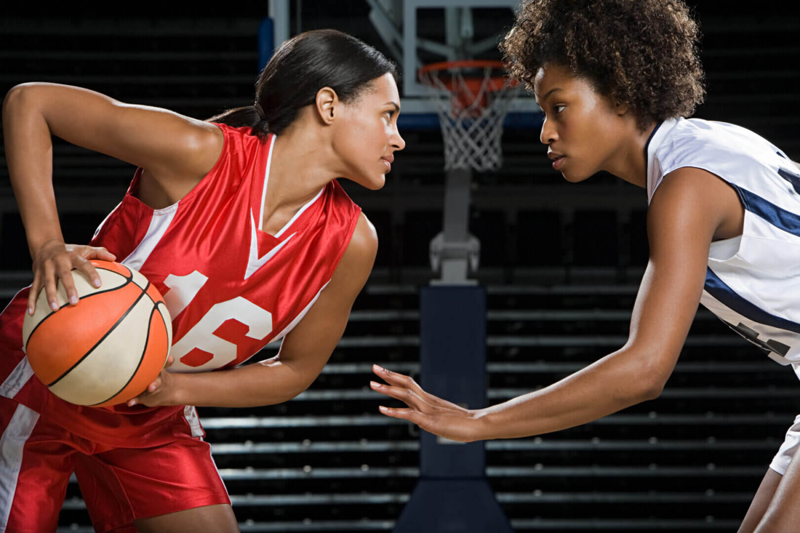 Basketball players in intense face-off moment.