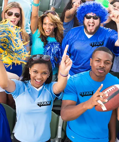 Excited sports fans in blue cheering passionately at a game.