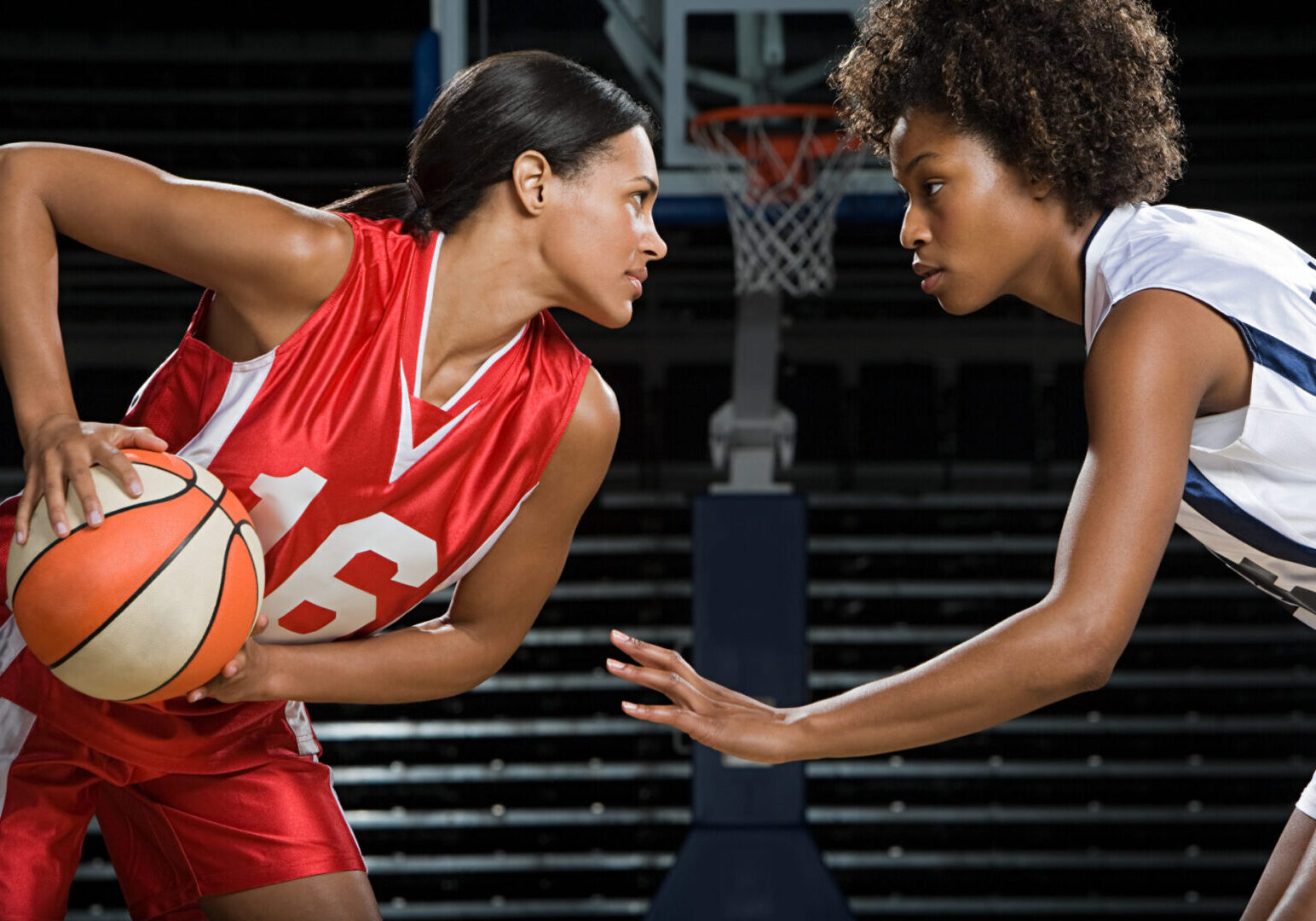 Basketball players in intense face-off moment.